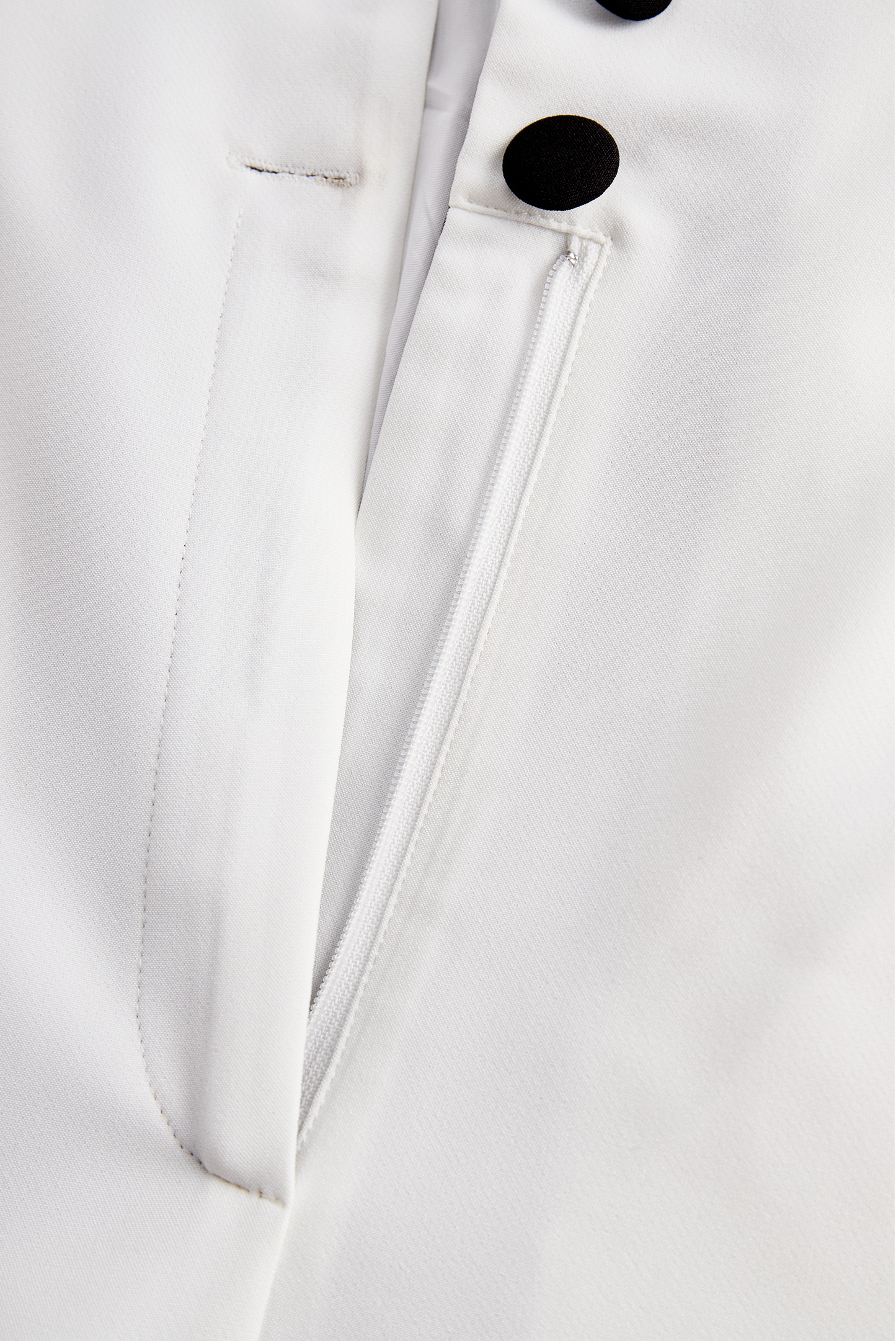 Eleganten bel kombinezon z dvojnimi gumbi in črnim reverjem 