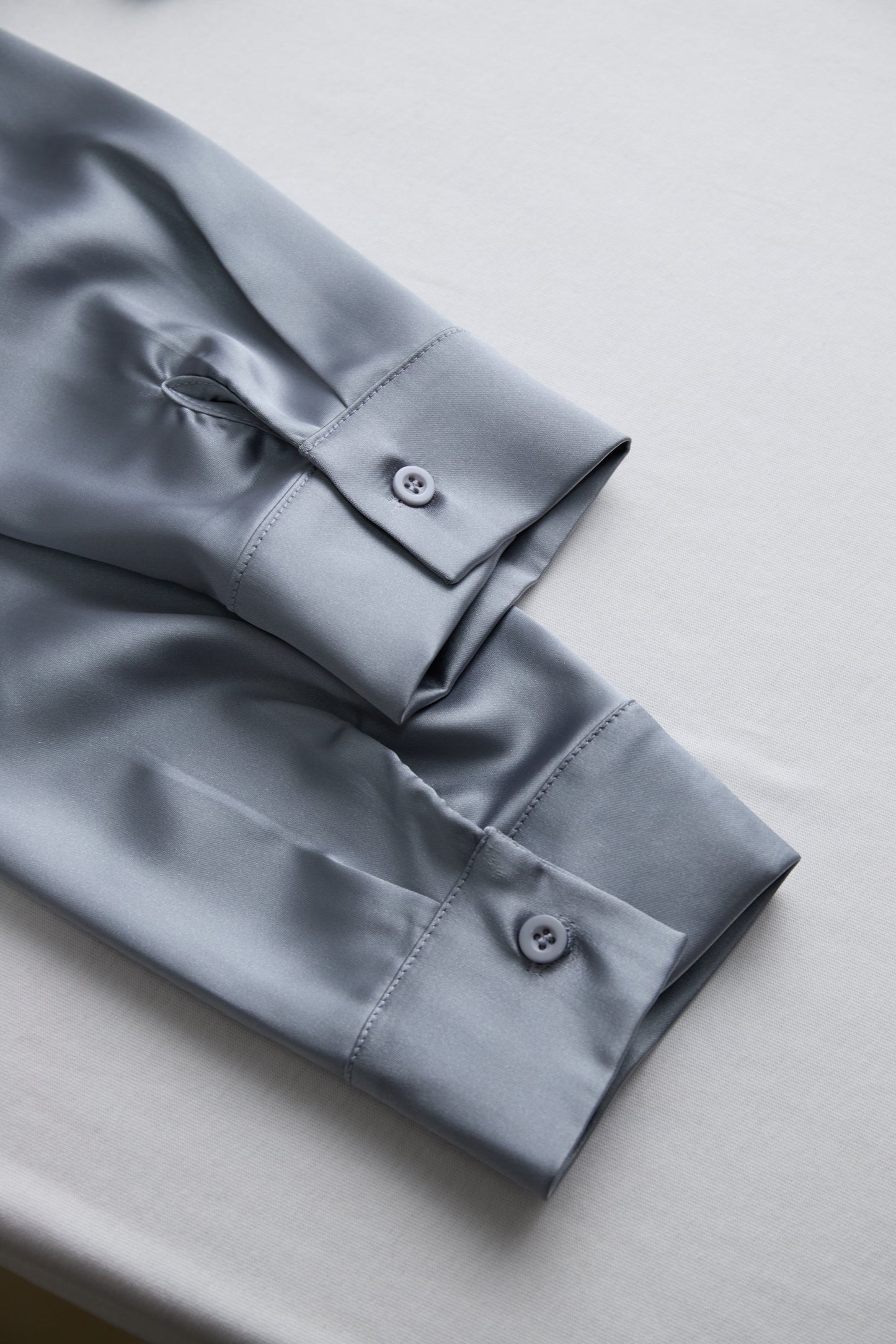 Srebrna satenasta bluza z globokim V-izrezom 