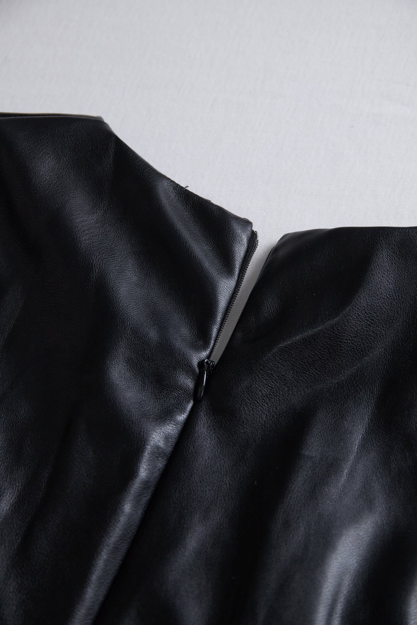 Elegantna črna mini obleka iz umetnega usnja z ovijanjem 