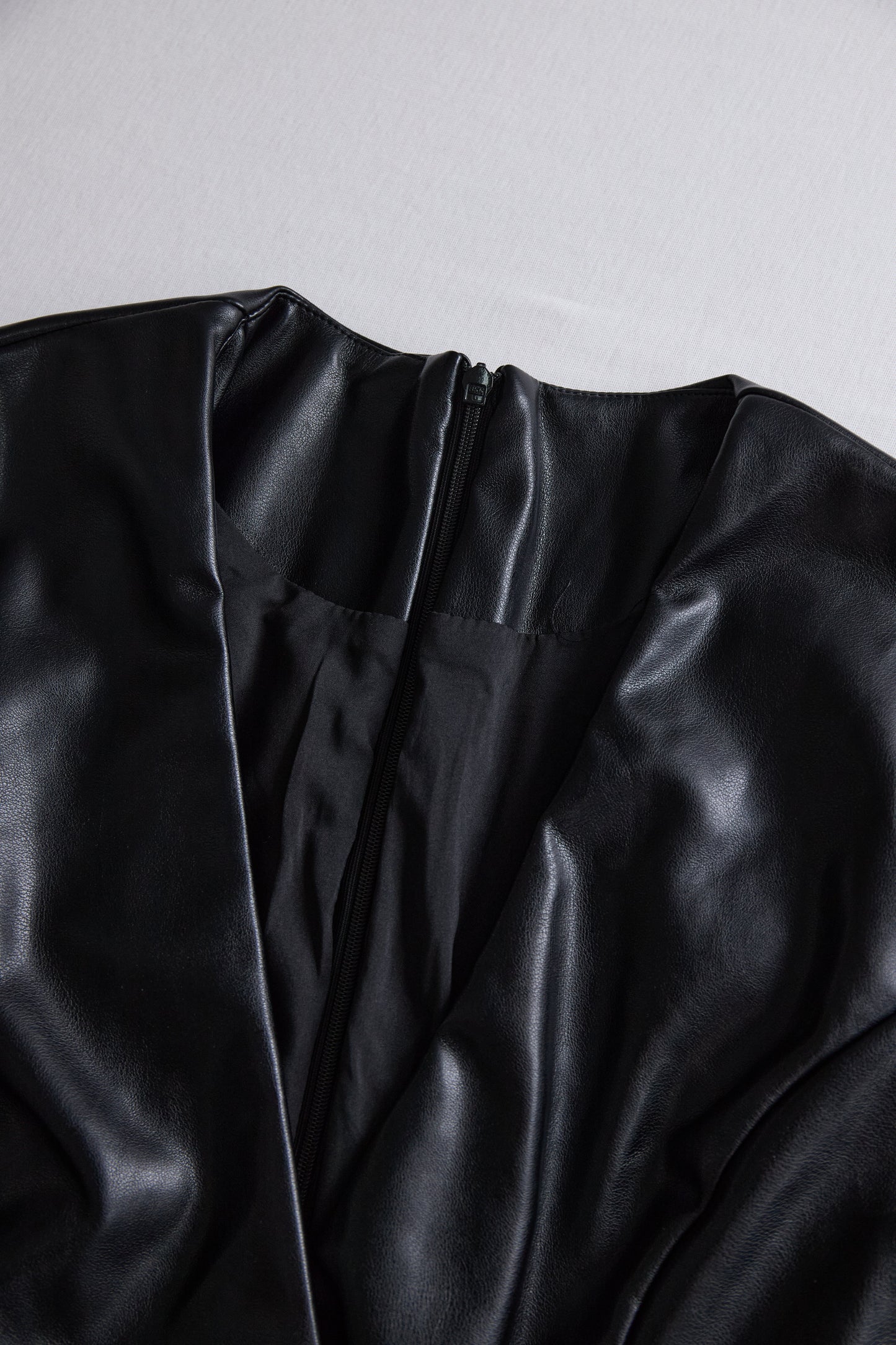 Elegantna črna mini obleka iz umetnega usnja z ovijanjem 