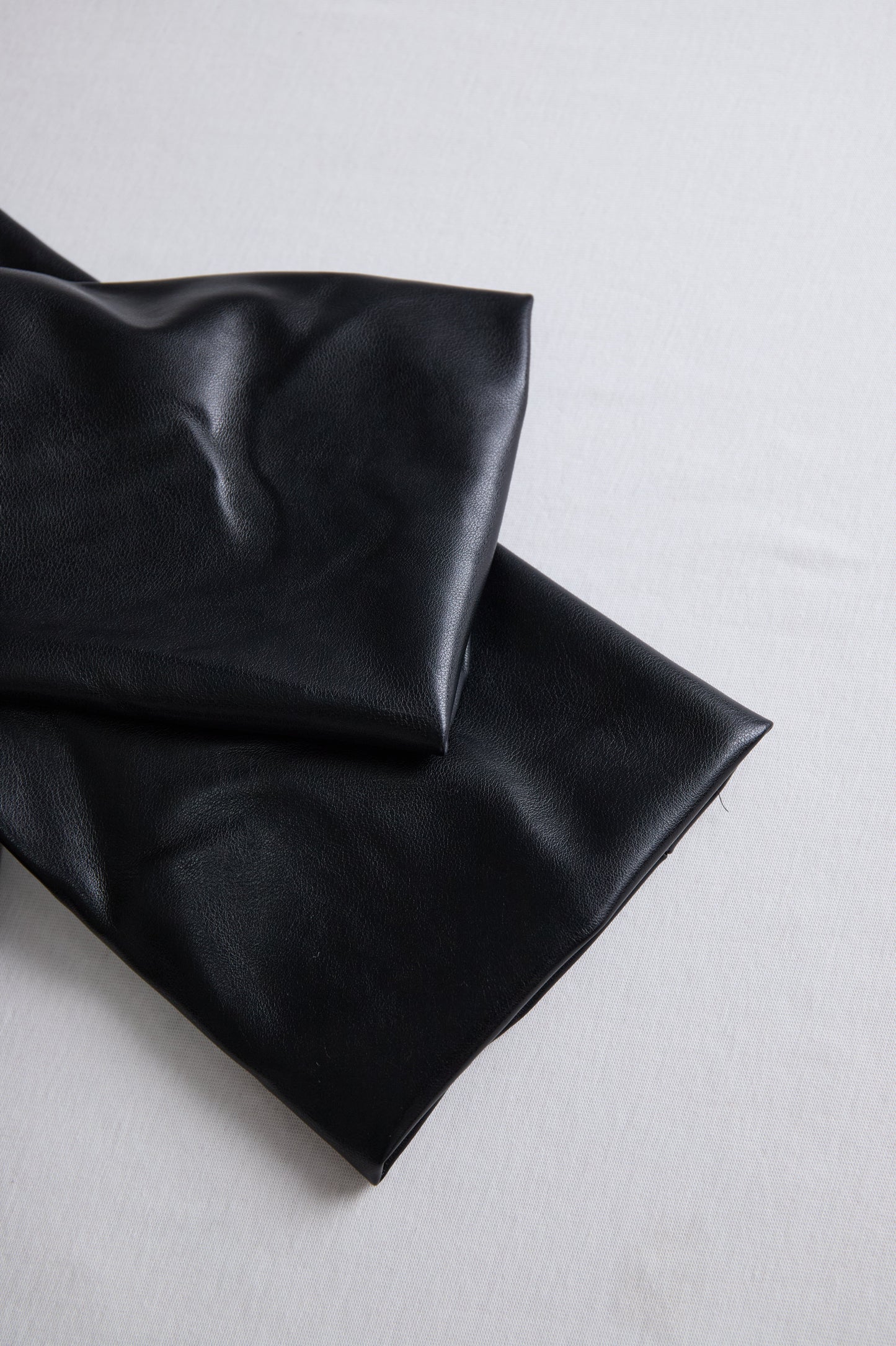 Elegantna črna mini obleka iz umetnega usnja z ovijanjem 