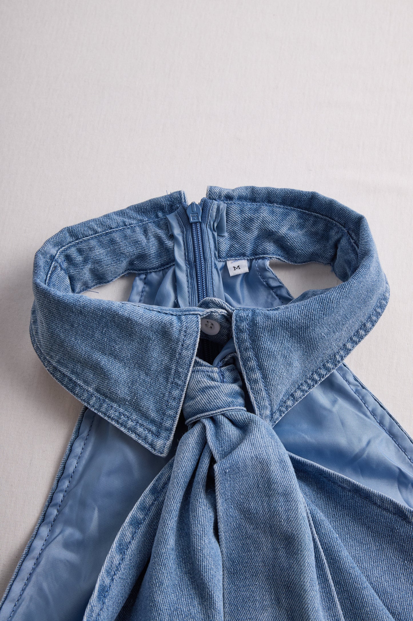 Elegantna bluza brez rokavov z vezalko na vratu 