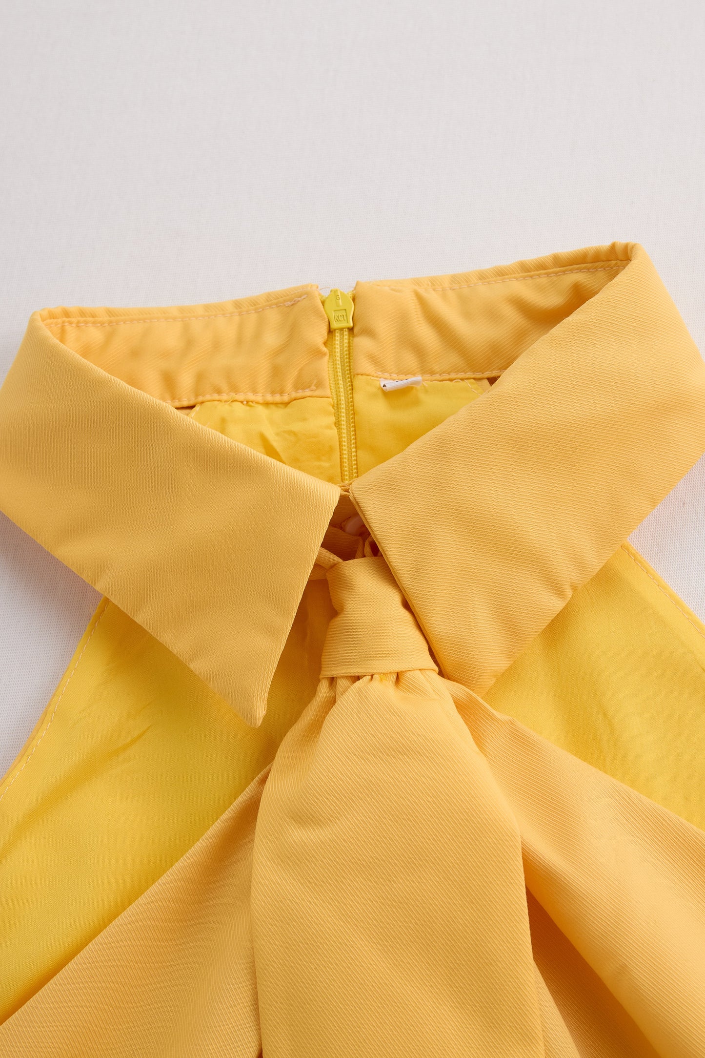 Elegantna bluza brez rokavov z vezalko na vratu 