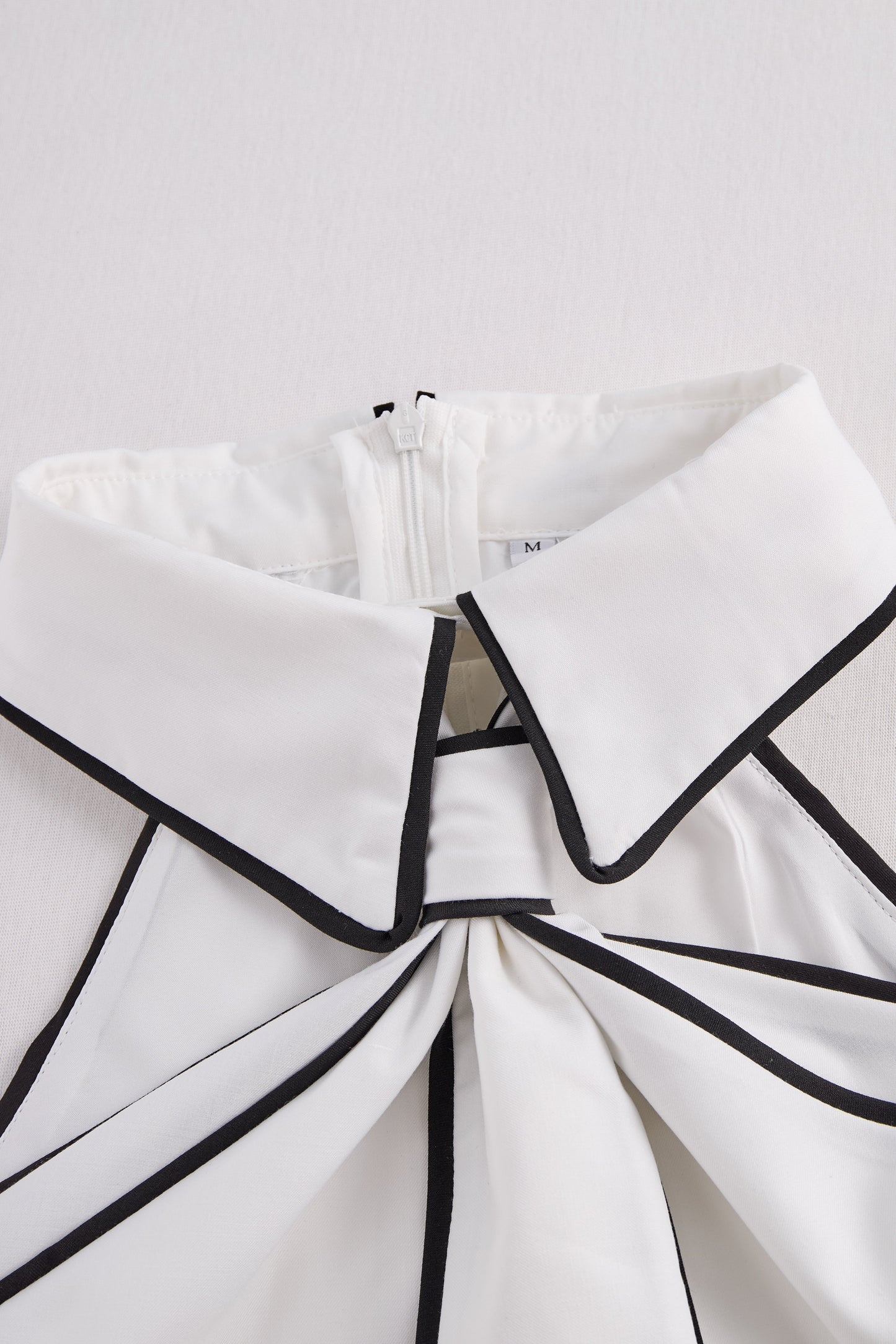 Elegantna bluza brez rokavov z ovratnikom in drzno kontrastno obrobo 