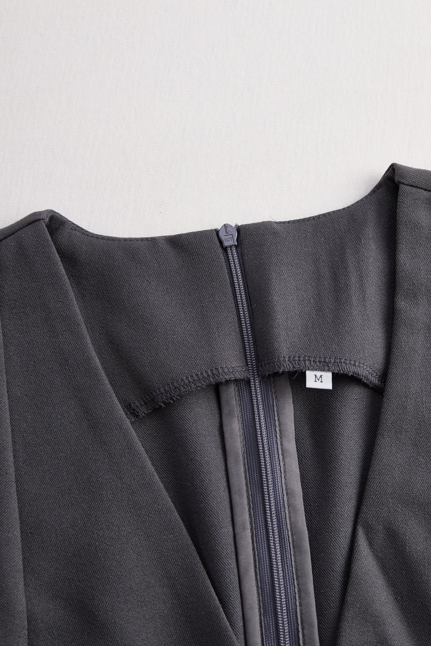 Prefinjen kombinezon brez rokavov peplum v temno sivi barvi